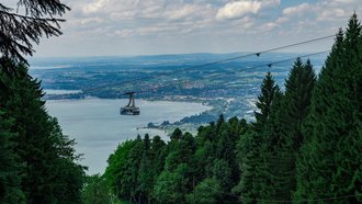 Der Bodensee vom Pfänder aus fotografiert. In mitten des Bildes ist diie Seilbahn zu sehen.